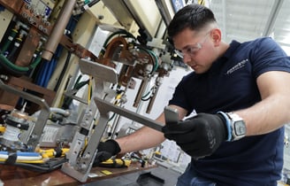 Fotografía de procesos productivos mostrando empleados trabajando en línea de producción