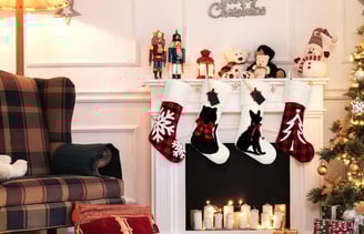 a christmas tree with stockings and stockings hanging on a fireplace