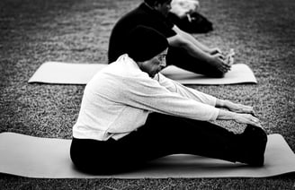 A man and woman doing outdoor yoga on a mat. Photo @hazmiljapilus / @jetpacklangkawi