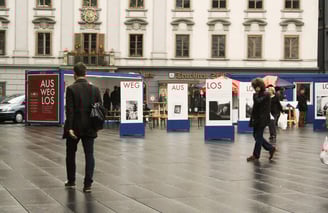 Menschen gehen durch die Ausstellung "Aus weg los!" auf der Grazer Hauptplatz.
