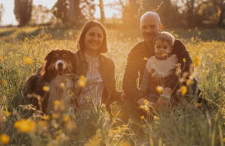 ragazza-ragazzo-e-bambino-con-cane-in-un-campo-al-tramonto