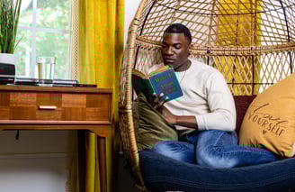 a man sitting in a chair reading a book