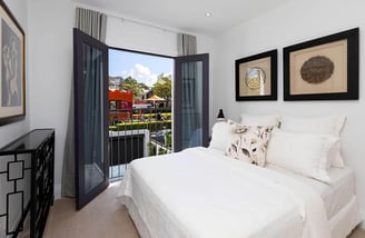 Elegant bedroom design in a renovated Victorian house, with French doors opening to a Juliet balcony