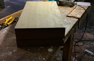 a wooden box with a piece of wood on top of a table