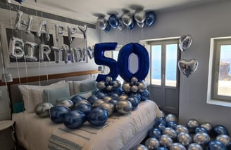 Helium balloons with metallic finishes floating in a beautifully decorated room.