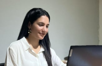 a woman sitting at a table with a laptop