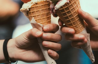 two ice cream cones one strawberry and one pistachio
