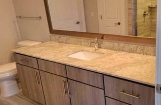 Clean and sanitized bathroom vanity with polished countertop, mirror, and sink area.