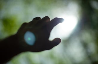 a hand reaching for a light out of focus