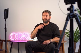 a man sitting in a chair with a camera and a camera
