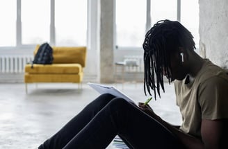 Jovem ouvindo música com fones – Relaxamento como estímulo para ideias criativas.