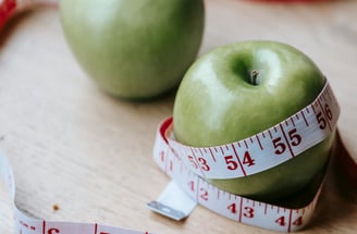 Green apples with a body measuring tape around it 