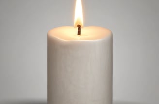 A cluster of white candles is burning amid a bed of flowers, predominantly white chrysanthemums and red roses. The background includes a stone surface with indistinct writing, possibly a memorial or grave marker. The atmosphere is solemn and reverent.