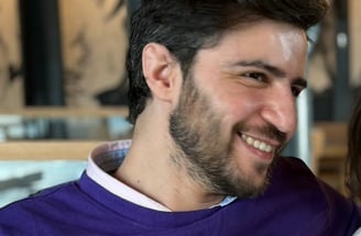 Adem Asha in a pink shirt
