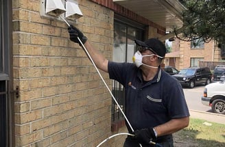 a man in a mask and gloves is cleaning dryer vent