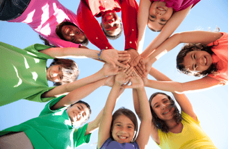 a group of people standing in a circle with their hands together