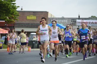A photo of runners sprinting away from the starting line of the Athens Alabama Chick Fil A 10K start