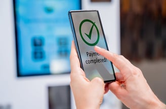 a person holding a phone that says payment completed