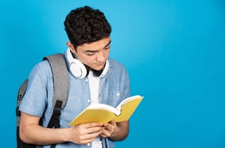 a man in a blue shirt and headphones is reading a book