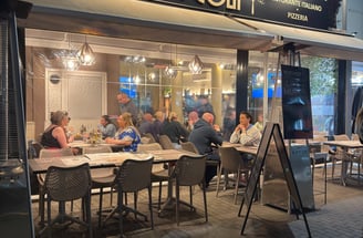 a restaurant with people sitting at tables outside