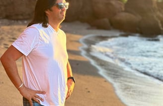 a man standing on a beach with a surfboard