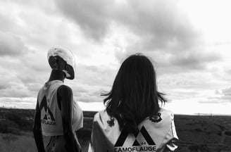 a dimensional being and woman standing in a field