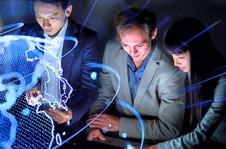 Two female and two male leaders using smart devices in front of a holographic globe