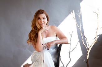 a woman in a white dress sitting in a chair