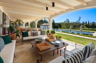 View from the shaded porch across the pool and gardens of Villa La Gratitud