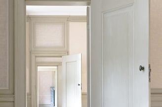 Photographie de portes blanches ouvertes et en enfilade, perspective d'un couloir