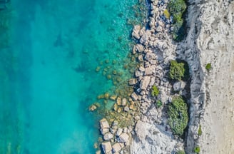 a person standing on a rock formation in the water