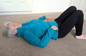 woman lying on carpet with knees raised