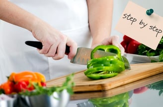 a person cutting a bellpepper on a cutting board