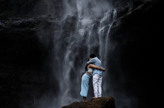 a couple standing in front of a waterfall.pre-wedding photography.