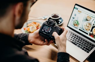 Ragazzo che imposta fotocamera davanti a laptop