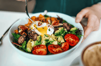 a person is eating a salad with eggs and eggs