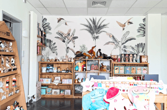 Transformation d'un magasin de jouets avec papier peint fleuri et meubles en bois
