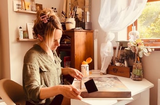 Applying the final layer of varnish to a painting