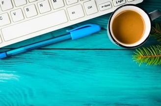A keyboard and a cup of tea on a desk, symbolizing a calm and focused blogging environment