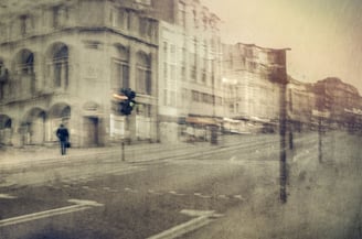 Historic London street scene photographed on a quiet morning with a single pedestrian and traffic light giving direction