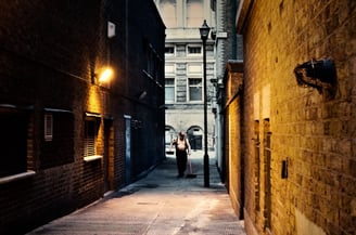 An early morning photograph of an elderly man without a shirt cleaning an alleyway in central London, captured early morning