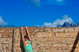 une femme surmonte un obstacle. Elle fait preuve de persévérance