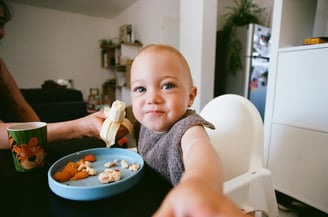 a baby is eating a banana in a bowl