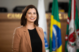 Amália Tortato mulher branca de cabelos castanho usando jaqueta marrom
