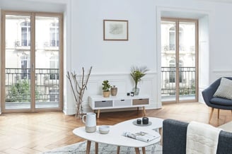 Salon moderne avec parquet en bois, équipé de grandes fenêtres mixtes bois-aluminium