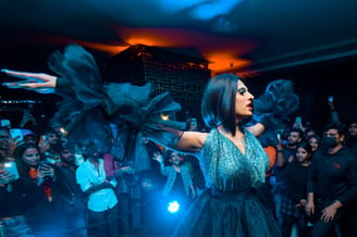 a woman in a black dress and a dj booth