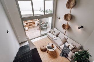 Modern living room with an iron staircase, natural wood finishes in Barcelona interior design