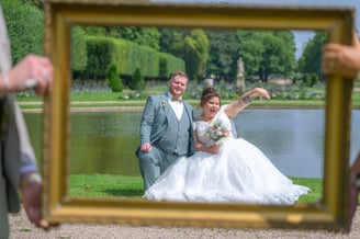 Un couple heureux prit en photo à travers un cadre de tableau