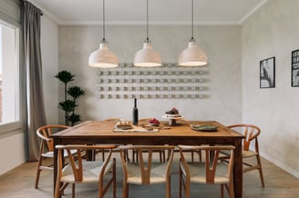 Dining area with elegant decor, wooden table and chairs, custom lighting and calming design by SAVIA