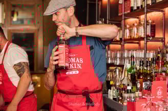 Thomas Dakin öffnet stellvertretend eine Flasche Gin.